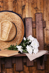 Hat with flowers on wooden background