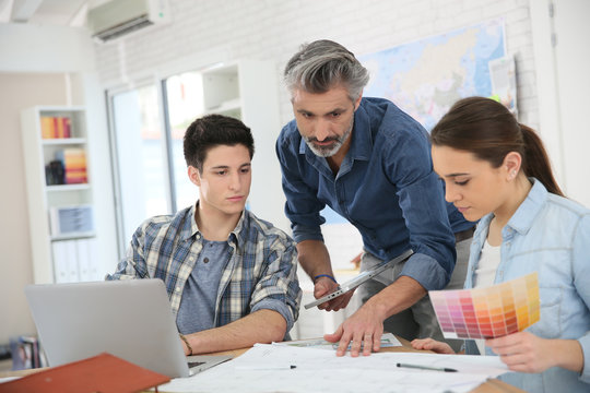 Teacher with students in architecture school