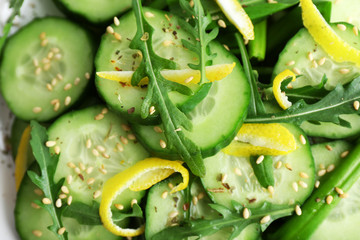 Green salad with cucumber, arugula and lemon peel, closeup
