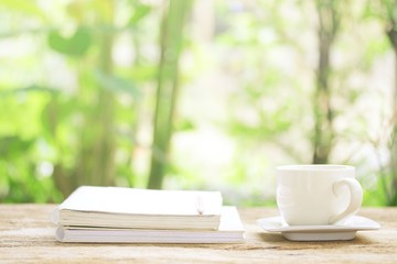 Notebook  and  white cup on wooden table