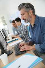 Smiling teacher working on desktop computer