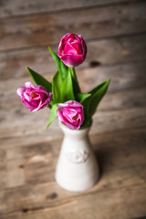 Vase of natural tulips. flowers on a wooden background