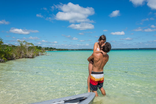 Beautiful couple in love looking at tranquil Bacalar lake. Rivie