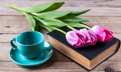 Cup of coffee on book with flowers.