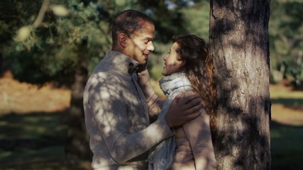 An attractive young couple enjoy a romantic moment together in the forest