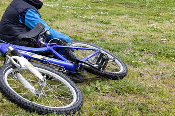 bambino con bicicletta seduto sul prato