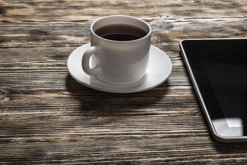 Fototapeta na wymiar Tablet. Digital white tablet and coffee cup on wooden table