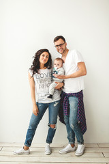 Hipster father, mother holding cute baby boy over white backgrou