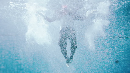 Drowning underwater businessman, treading water to try and stay afloat