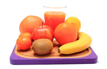 Fresh natural fruits and glass of juice on cutting board