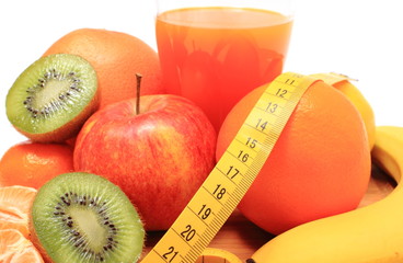 Fresh fruits, tape measure and glass of juice