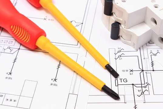 Screwdriver and electric fuse on construction drawing of house