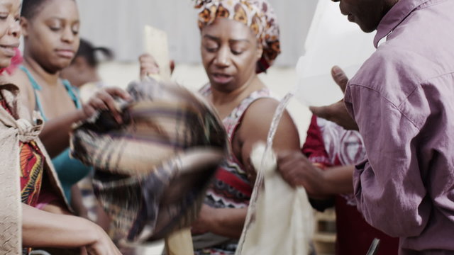 African family and community members work together, washing clothes by hand