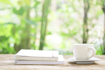 Notebook  and  white cup on wooden table