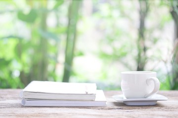 Notebook  and  white cup on wooden table