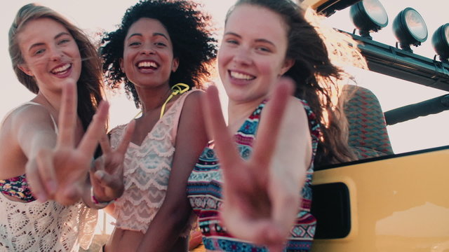 Happy Afro girl and friends smiling showing peace sign