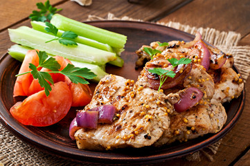 Sliced pork grilled with vegetables on ceramic brown plate