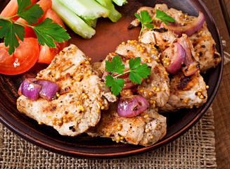 Sliced pork grilled with vegetables on ceramic brown plate