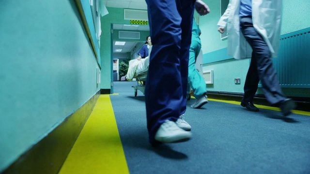 Hospital emergency team rush a patient on a gurney to the operating theatre