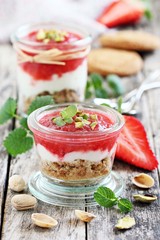 Dessert of oat cookies , yogurt, strawberries and pistachios