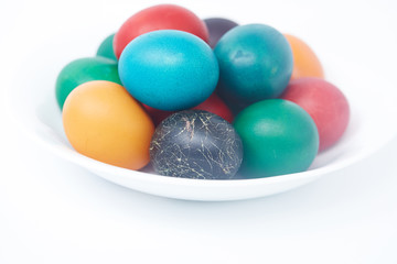 Easter colorful painted eggs on a white plate