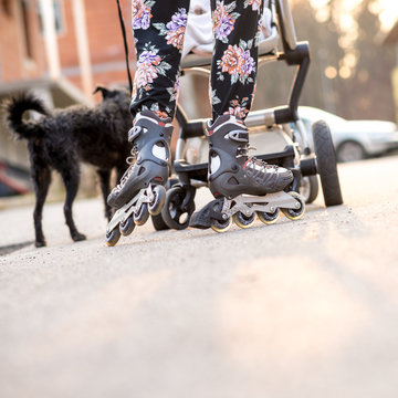 Woman Wearing Rollerblades Skating While Pushing Baby Stroller