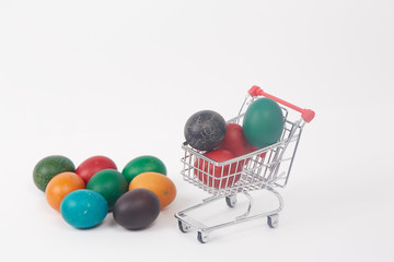 Easter colorful painted eggs in the shopping cart and near the t