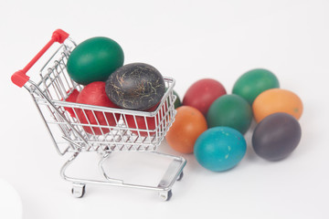 Easter colorful painted eggs in the shopping cart and near the t