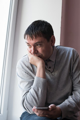 young man thinks the window