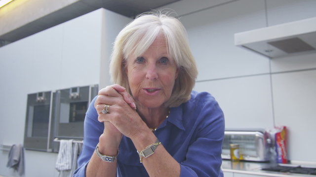 Happy attractive mature woman having a video chat from computer screen's pov