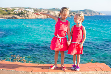 Fototapeta na wymiar Adorable little girls at tropical beach during summer vacation
