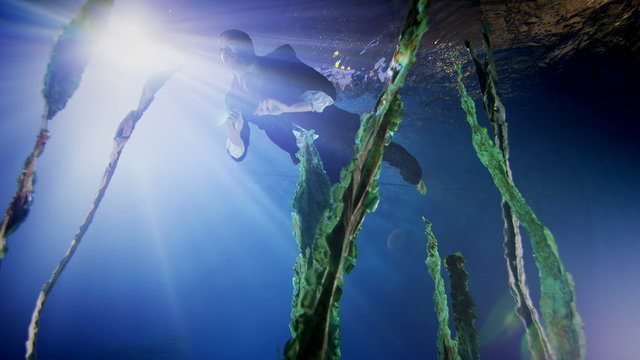 Underwater businessman swimming in deep blue water