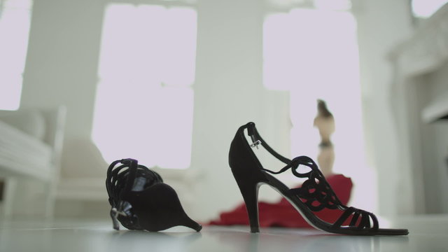 High heeled shoes and a crumpled evening gown on the floor