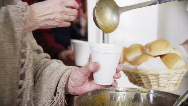 Feeding the hungry - eager hands take soup and bread