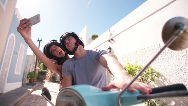 Couple on a scooter taking a selfie