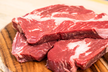 Fresh beef steaks on wooden board