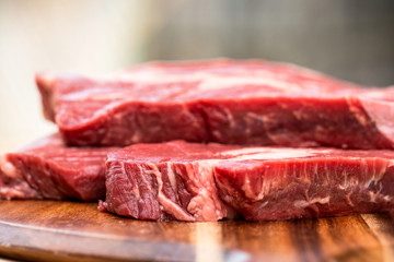 Fresh beef steaks on wooden board