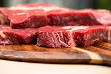 Fresh beef steaks on wooden board