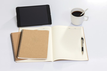 Blank notebook with digital tablet and coffee cup on white table