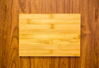 Yellow wood plate on brown texture wood background