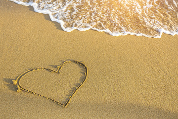 Heart drawn in sea beach sand.
