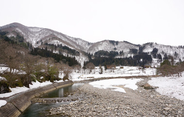 Winter river with snow all over and forest background
