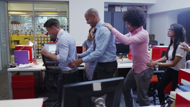 Funny business team doing a conga line through their office.