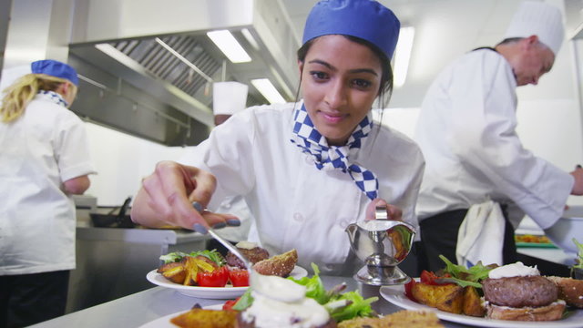 Delicious meal being given the finishing touches by chef in a commercial kitchen