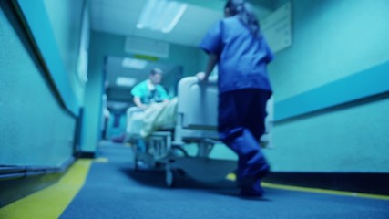 Hospital emergency team rush a patient on a gurney to the operating theatre - Powered by Adobe