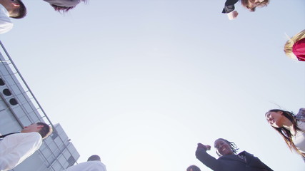 Business team stand in a circle with their hands together for a team talk - Powered by Adobe