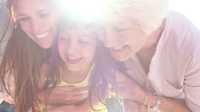 Laughing little girl with her mother and grandmother