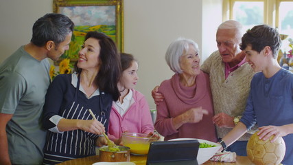 3 generations of happy family preparing a meal together in the kitchen at home - Powered by Adobe