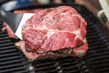 Beef steaks on grill or BBQ with spatula