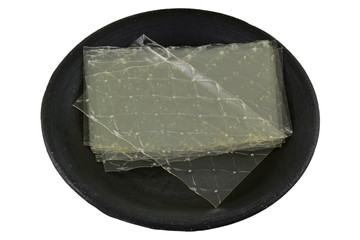 Sheets of Gelatin leaves on a dark ceramic plate
